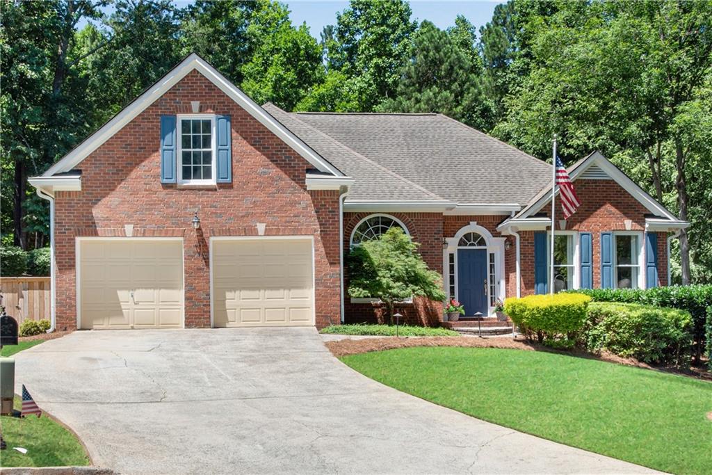 a front view of a house with a yard and trees