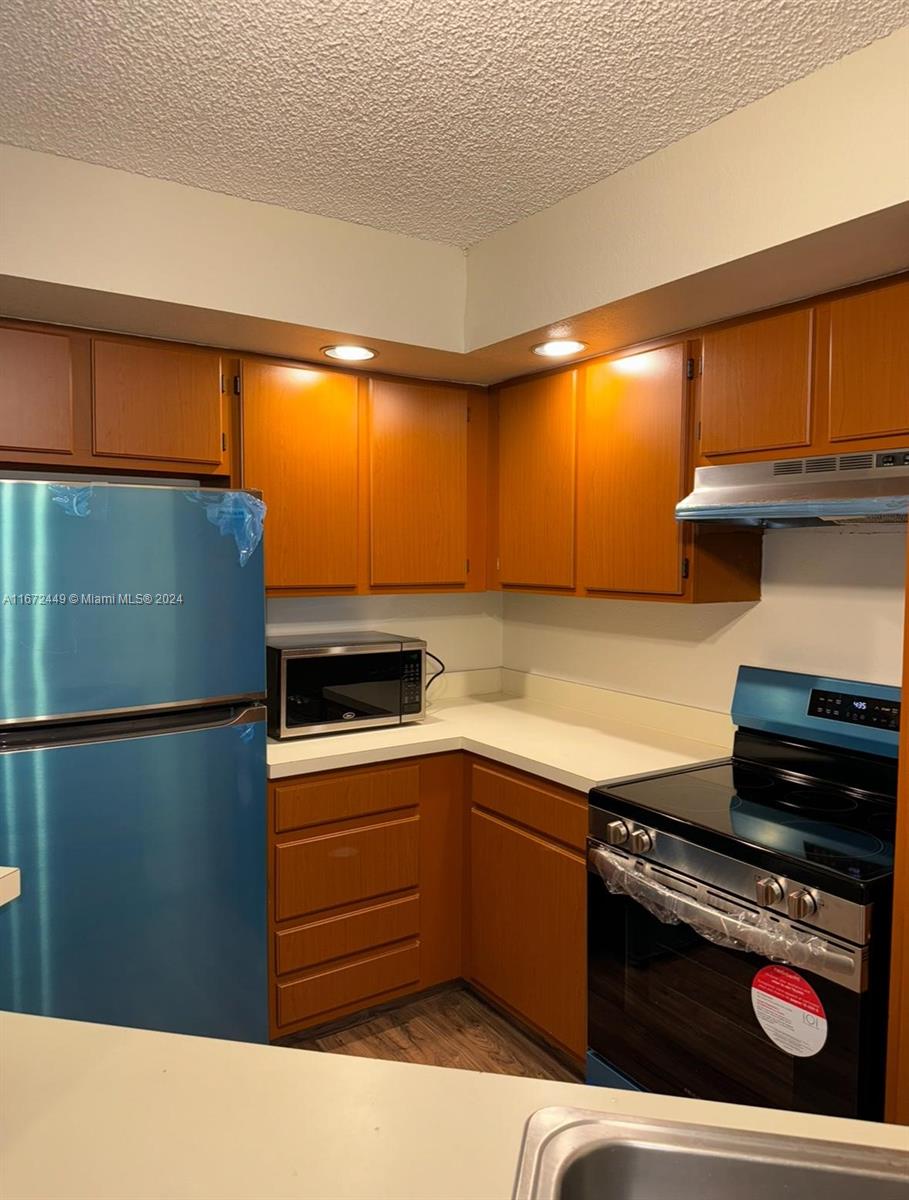 a kitchen with granite countertop stainless steel appliances and wooden cabinets