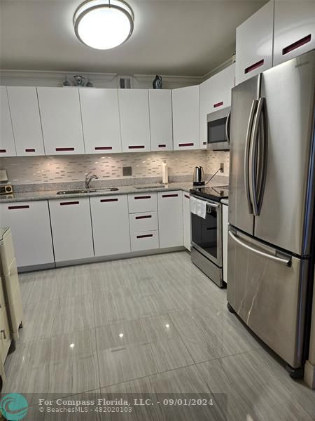 a kitchen with cabinets and stainless steel appliances