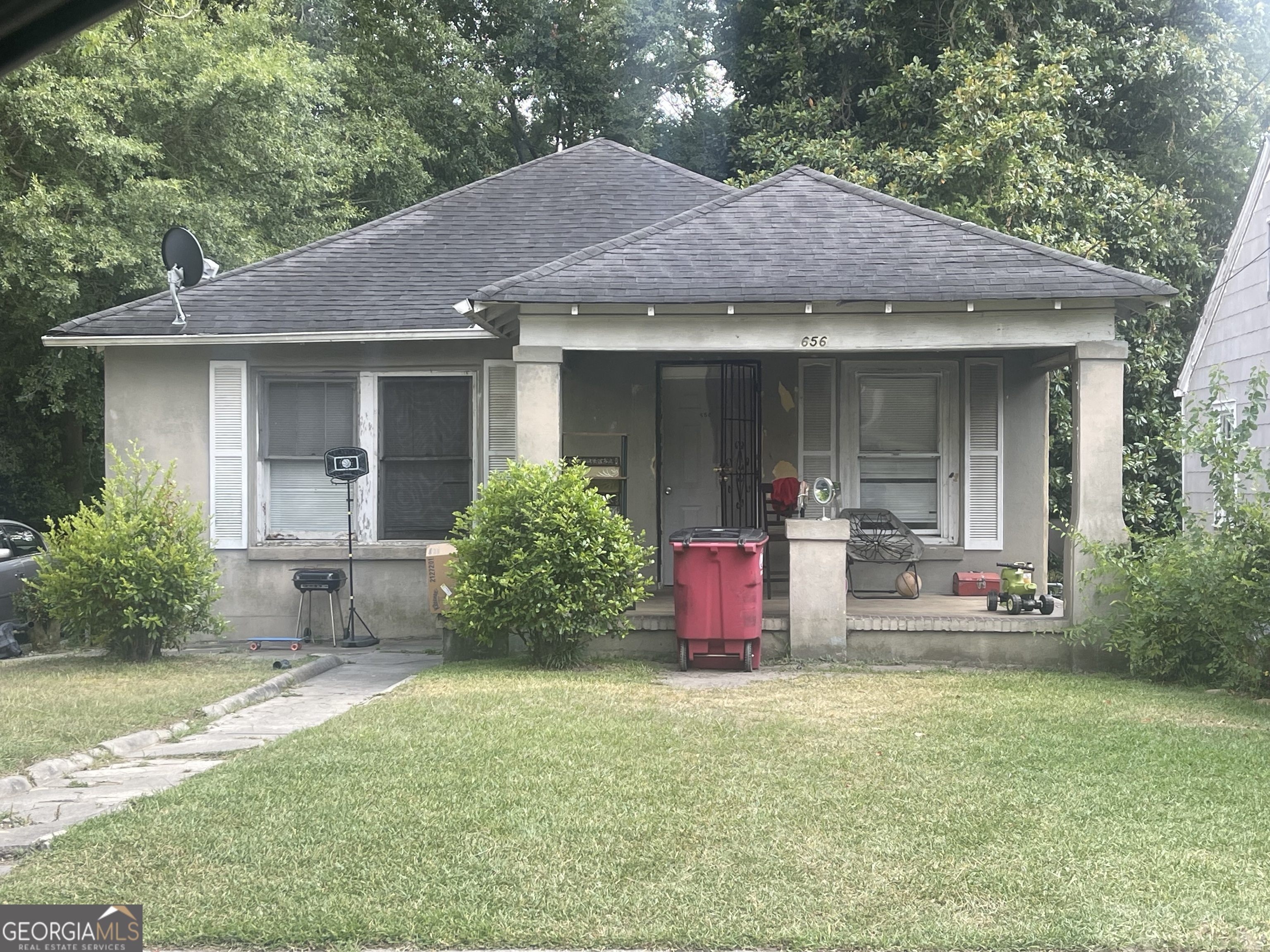 a front view of a house with a garden and plants