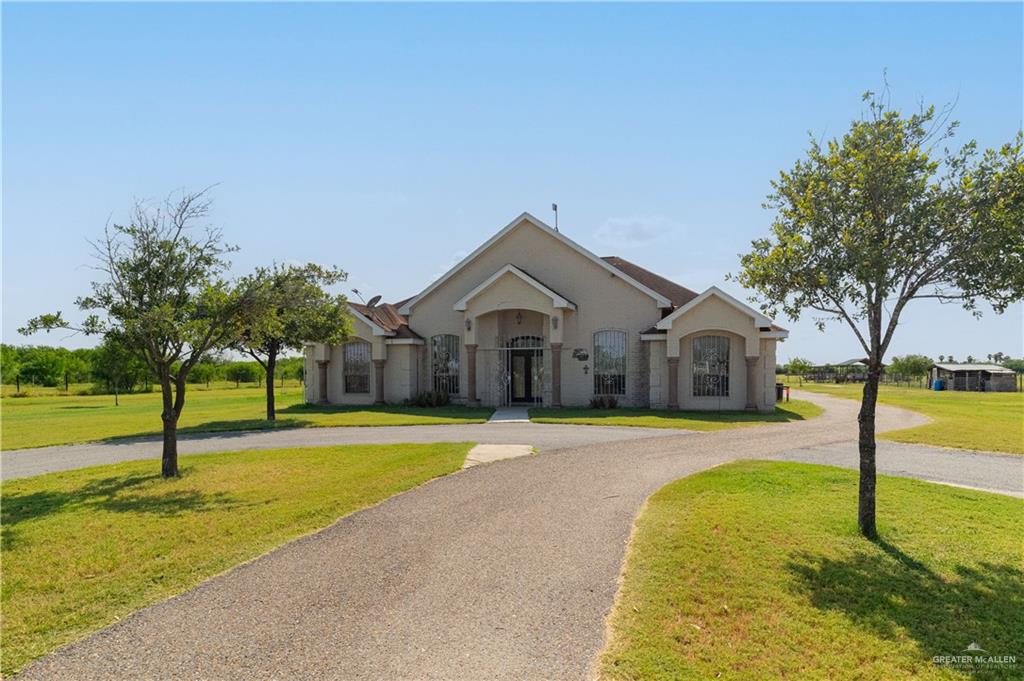 a view of a house with swimming pool and a yard