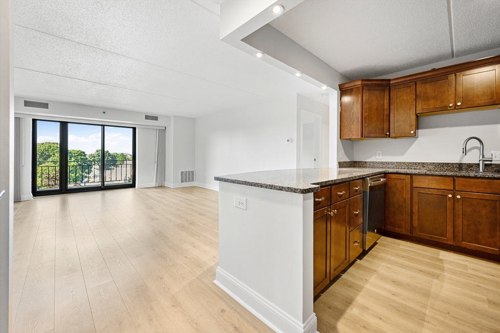 a kitchen with a refrigerator sink and wooden cabinets