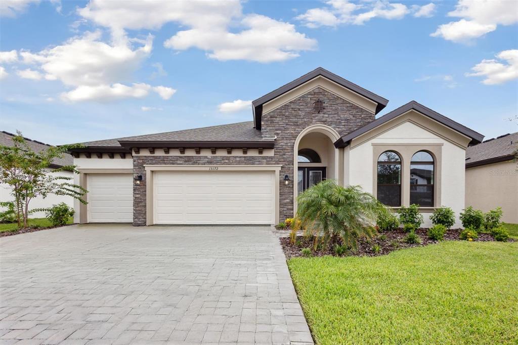 a front view of a house with a yard and garage