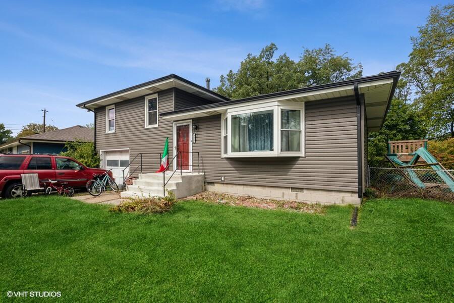 a view of a house with a yard and sitting area