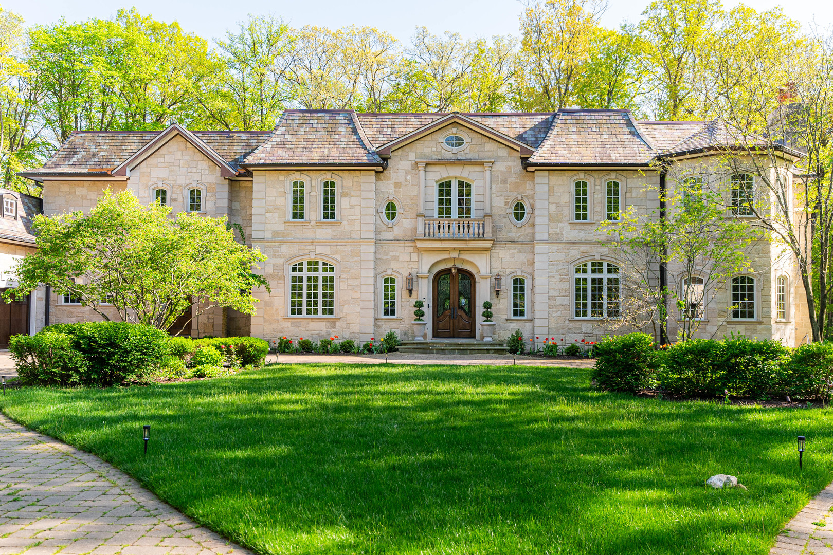 a front view of a house with a yard and trees