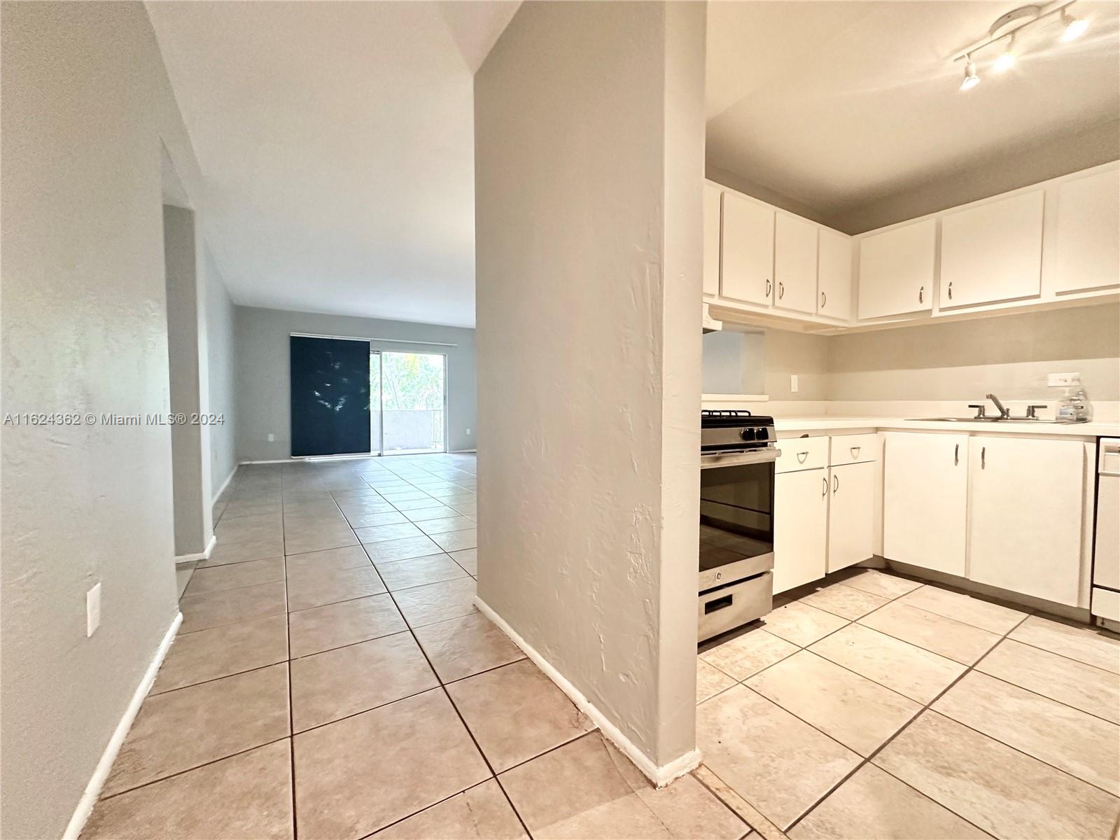 a view of kitchen with white cabinets and white appliances