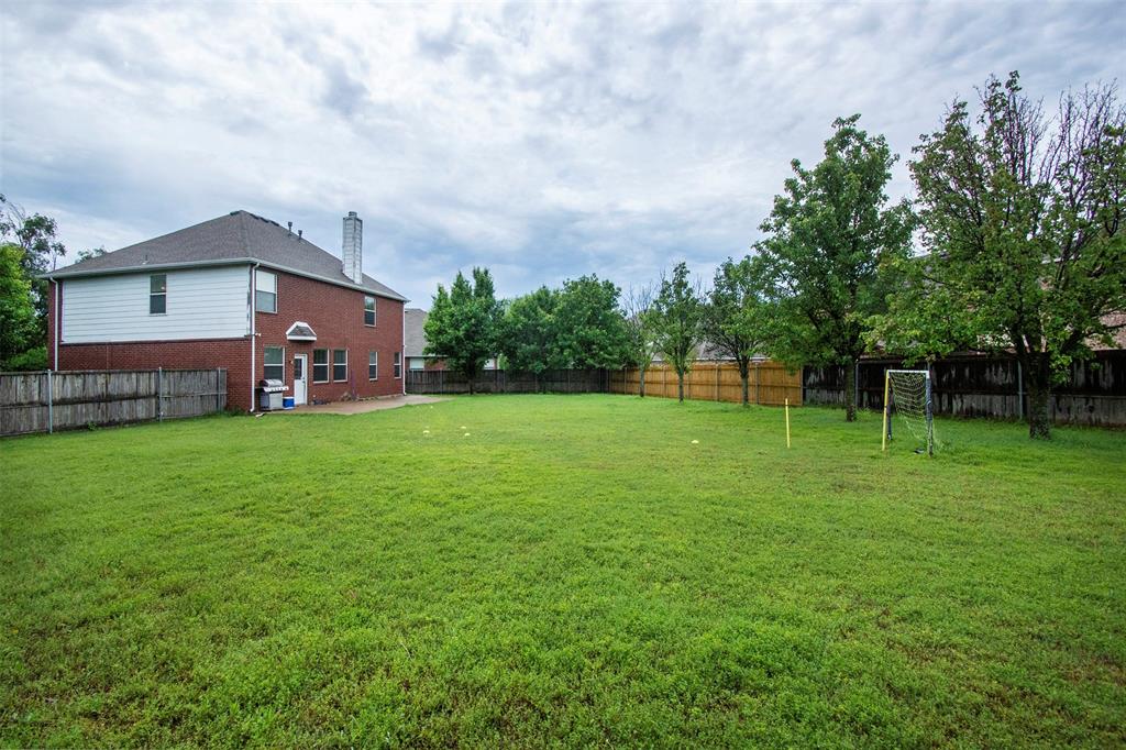 a view of a house with a big yard and large trees