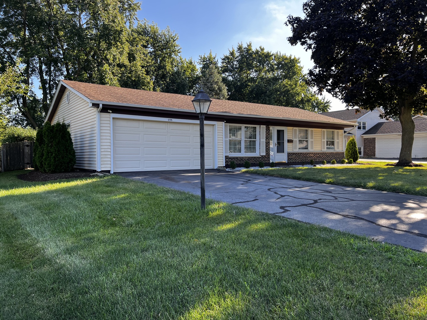 a view of a house with a yard and a large tree