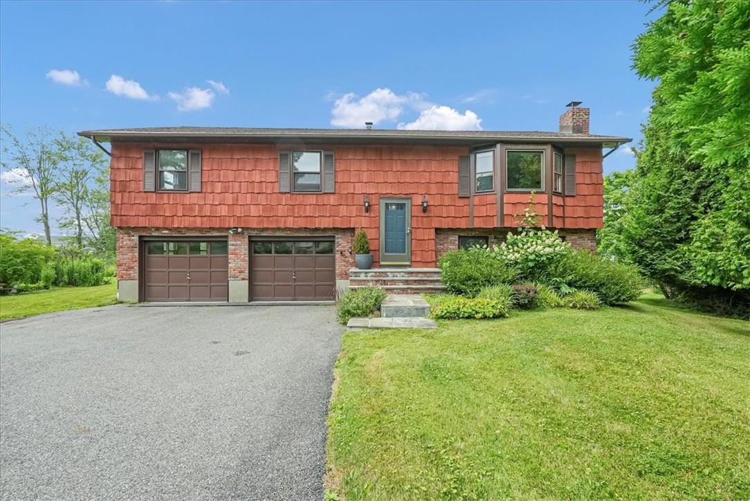 Split foyer home featuring a garage and a front yard