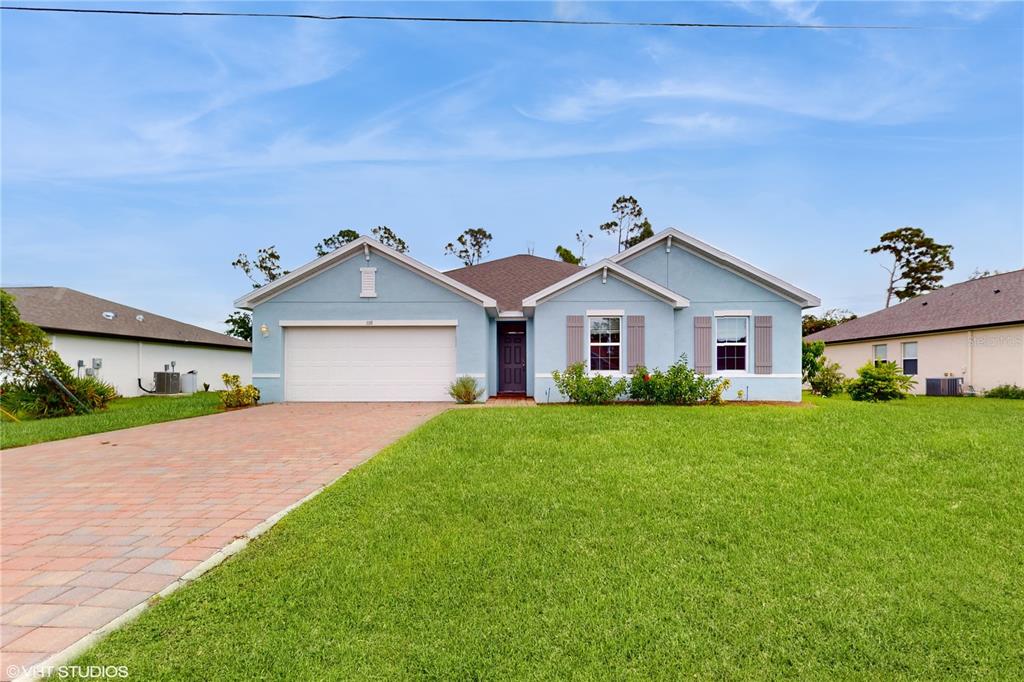 a front view of a house with a yard and garage