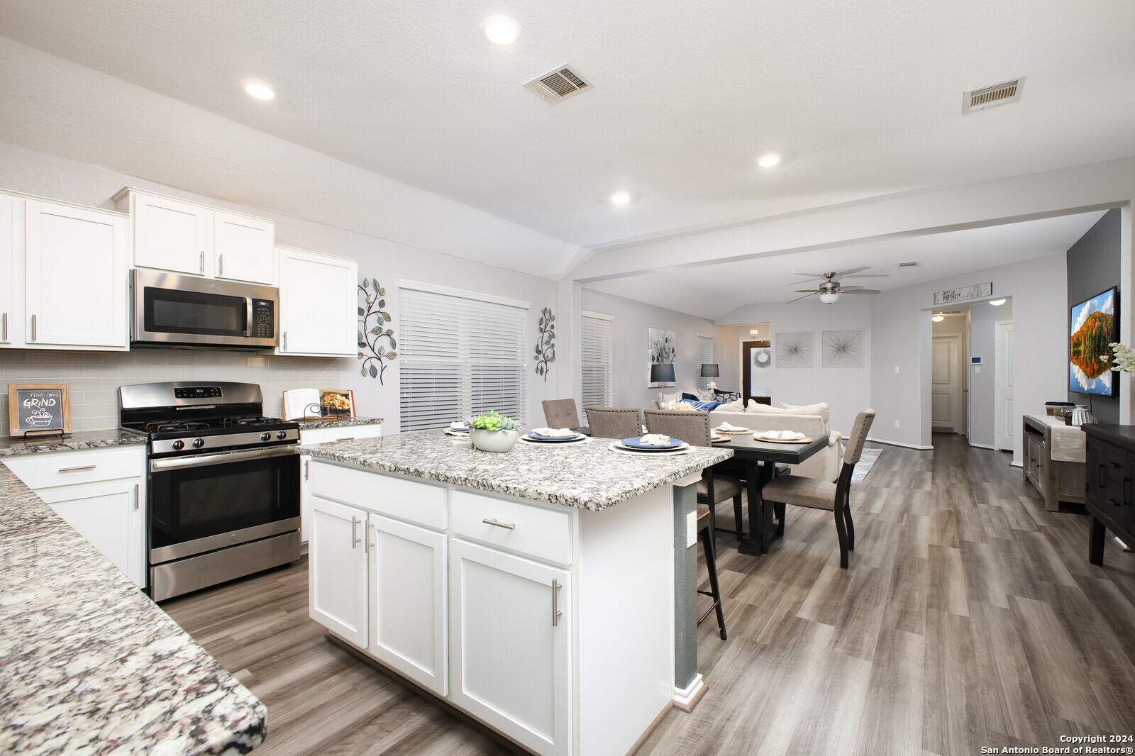 a kitchen with stainless steel appliances kitchen island granite countertop a sink and cabinets