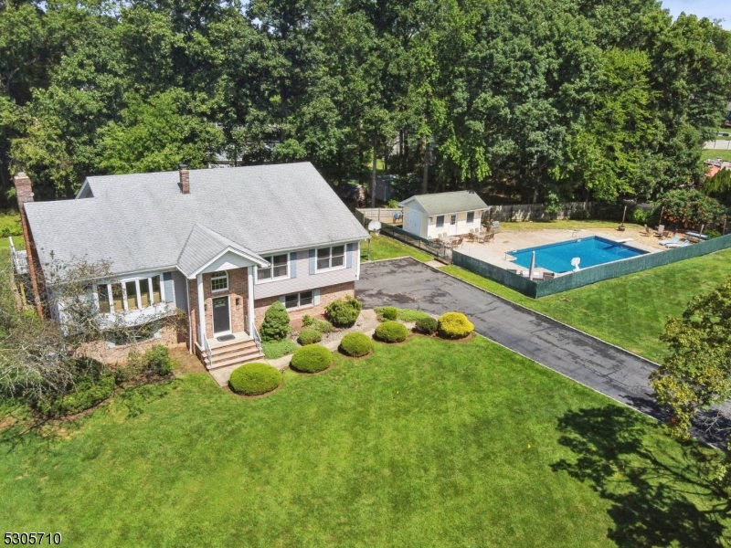 an aerial view of a house with swimming pool and big yard