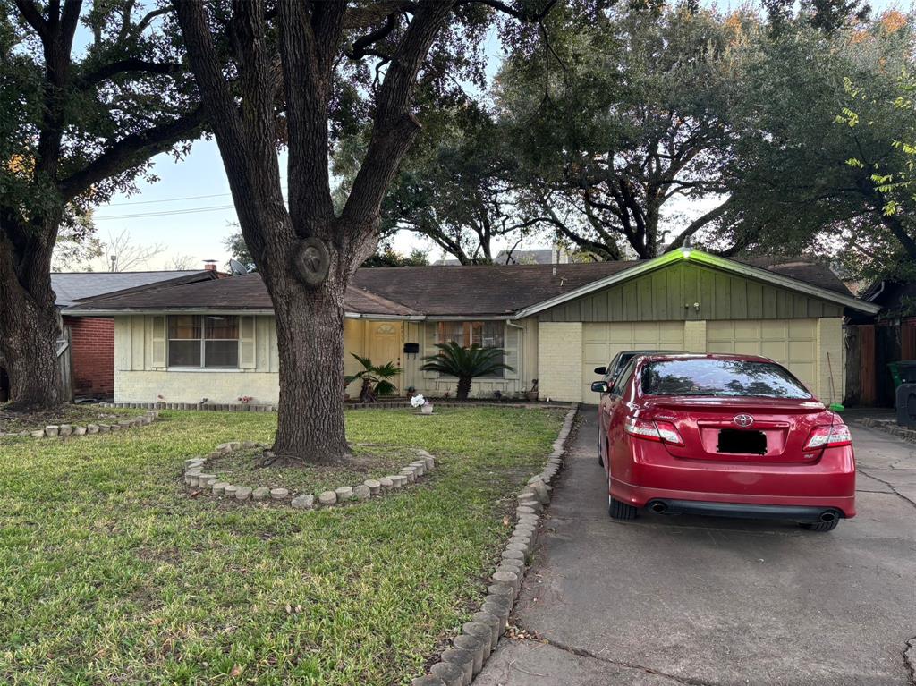 a front view of a house with a garden and trees