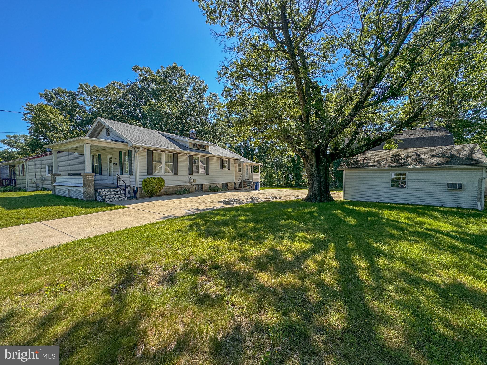 a view of a house with a yard patio and a tree