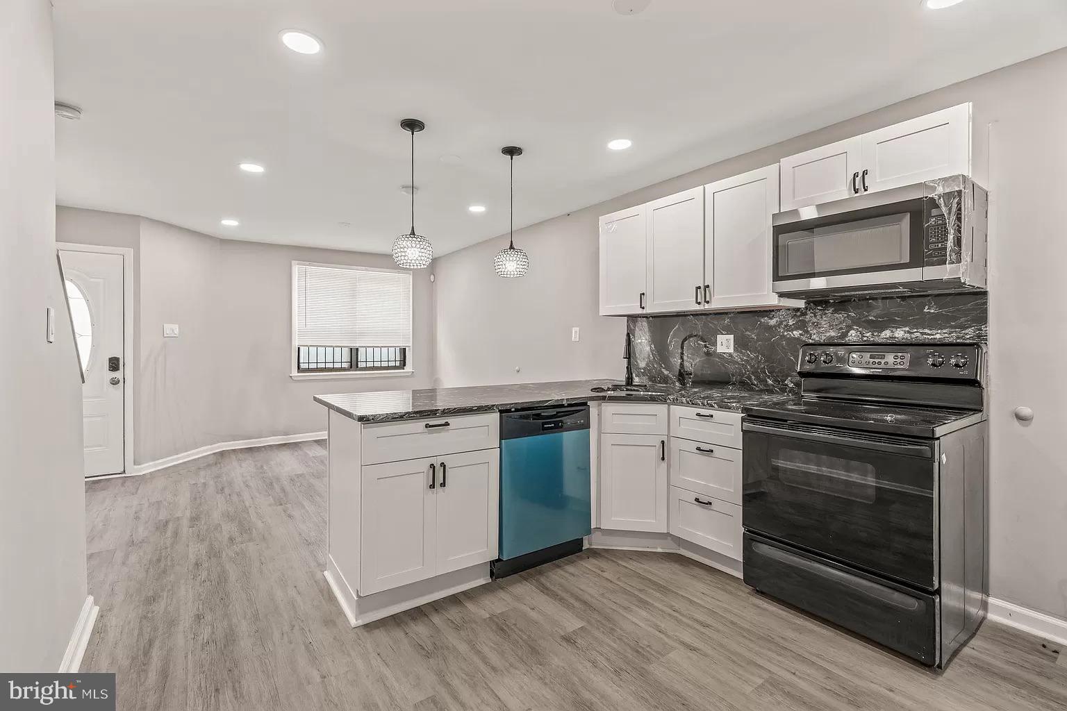 a kitchen with stainless steel appliances granite countertop a stove a sink and a microwave