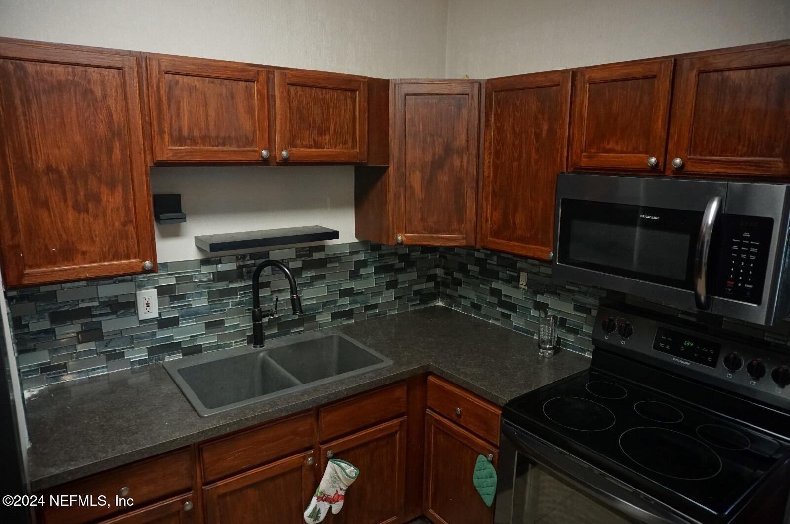 a kitchen with wooden cabinets and a stove top oven