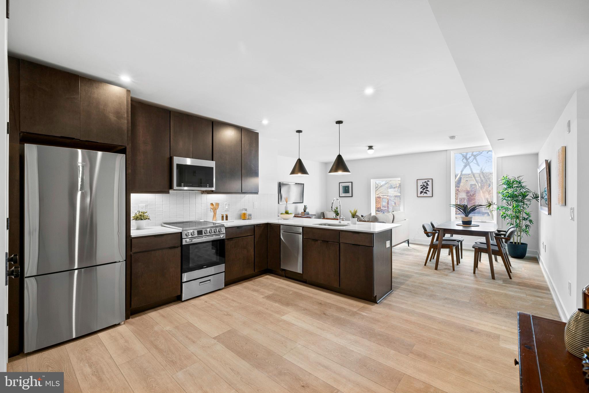 a large kitchen with lots of counter space a sink appliances and cabinets