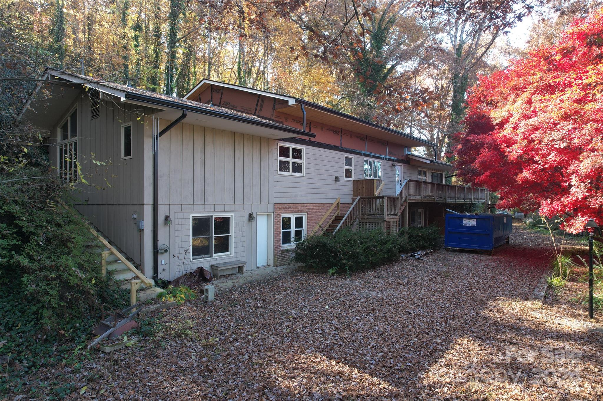 a view of house with a yard and large trees