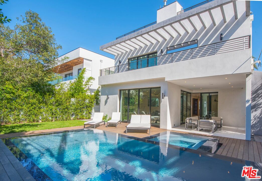 a view of a house with backyard and sitting area