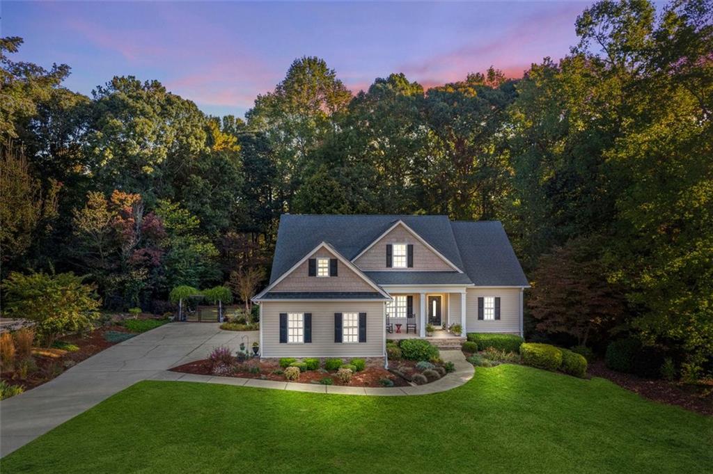 a front view of a house with a yard and trees