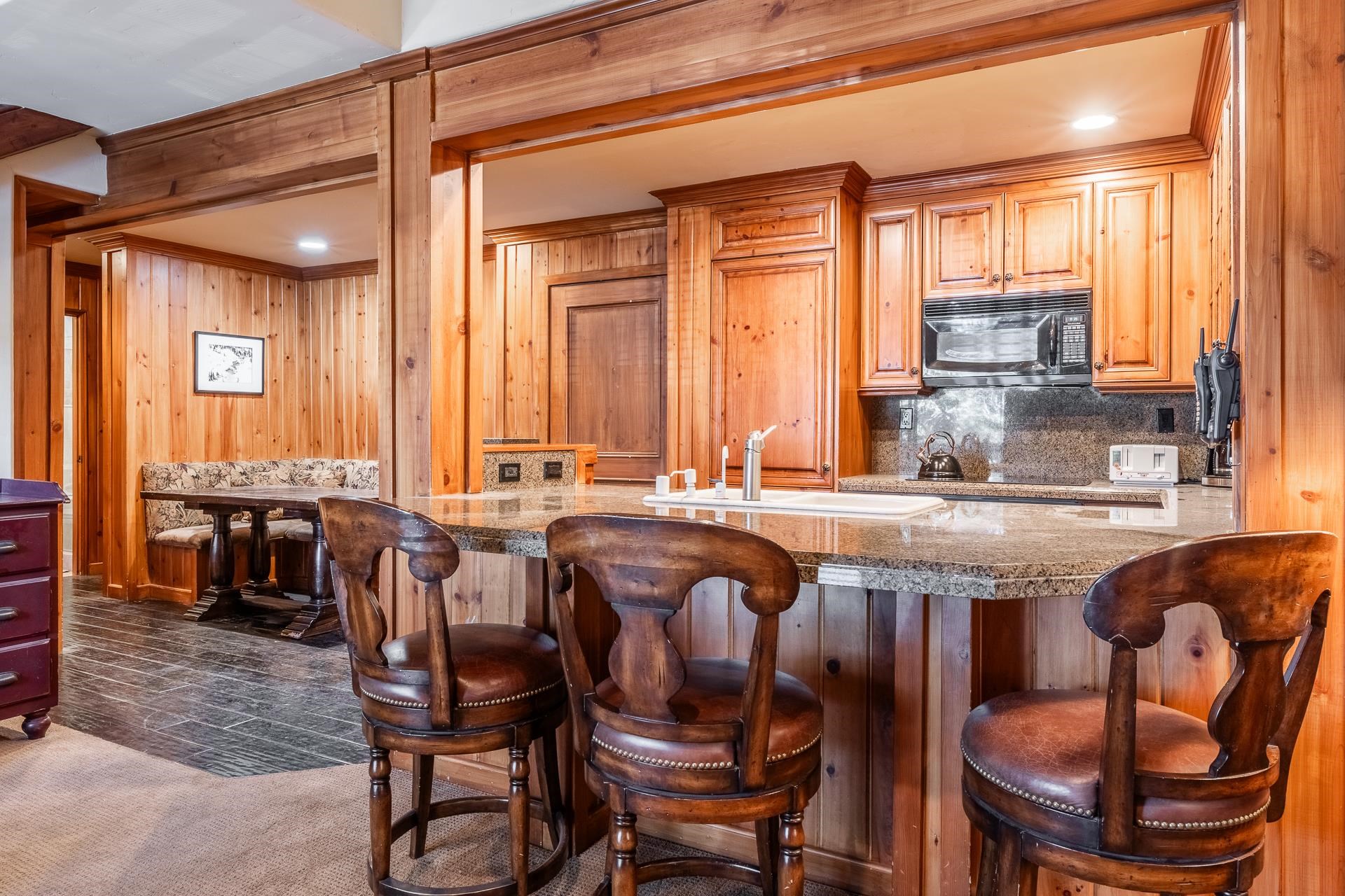 a dining hall with stainless steel appliances granite countertop a dining table and chairs