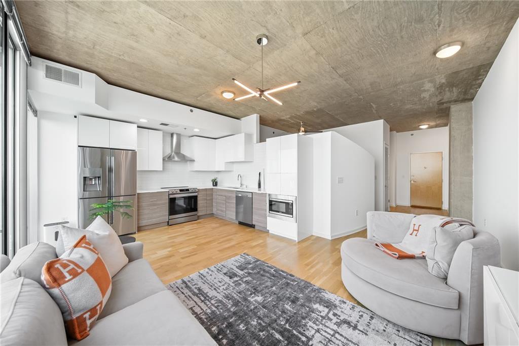 a living room with furniture and kitchen view