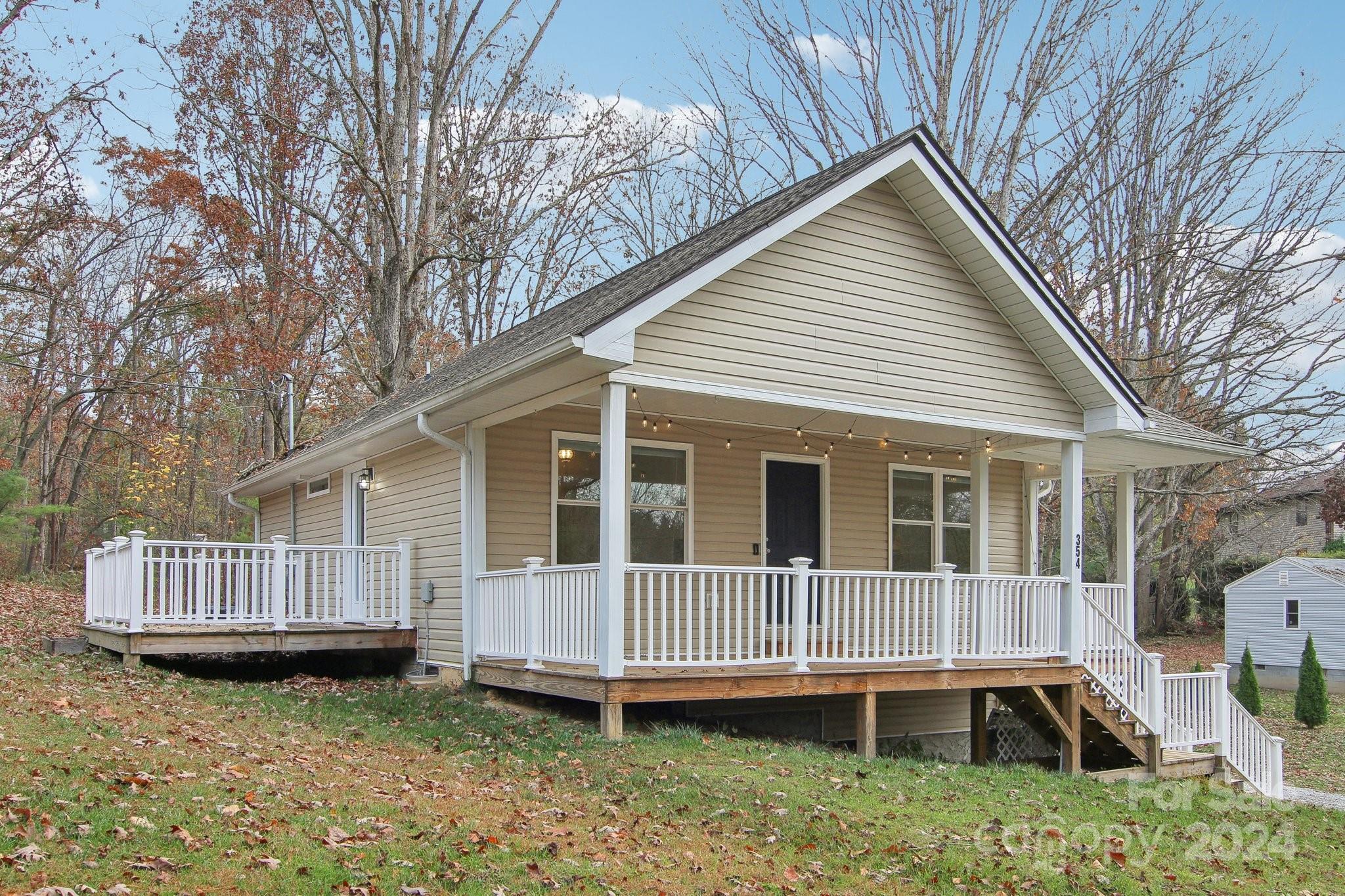 a view of a house with a yard and wooden deck