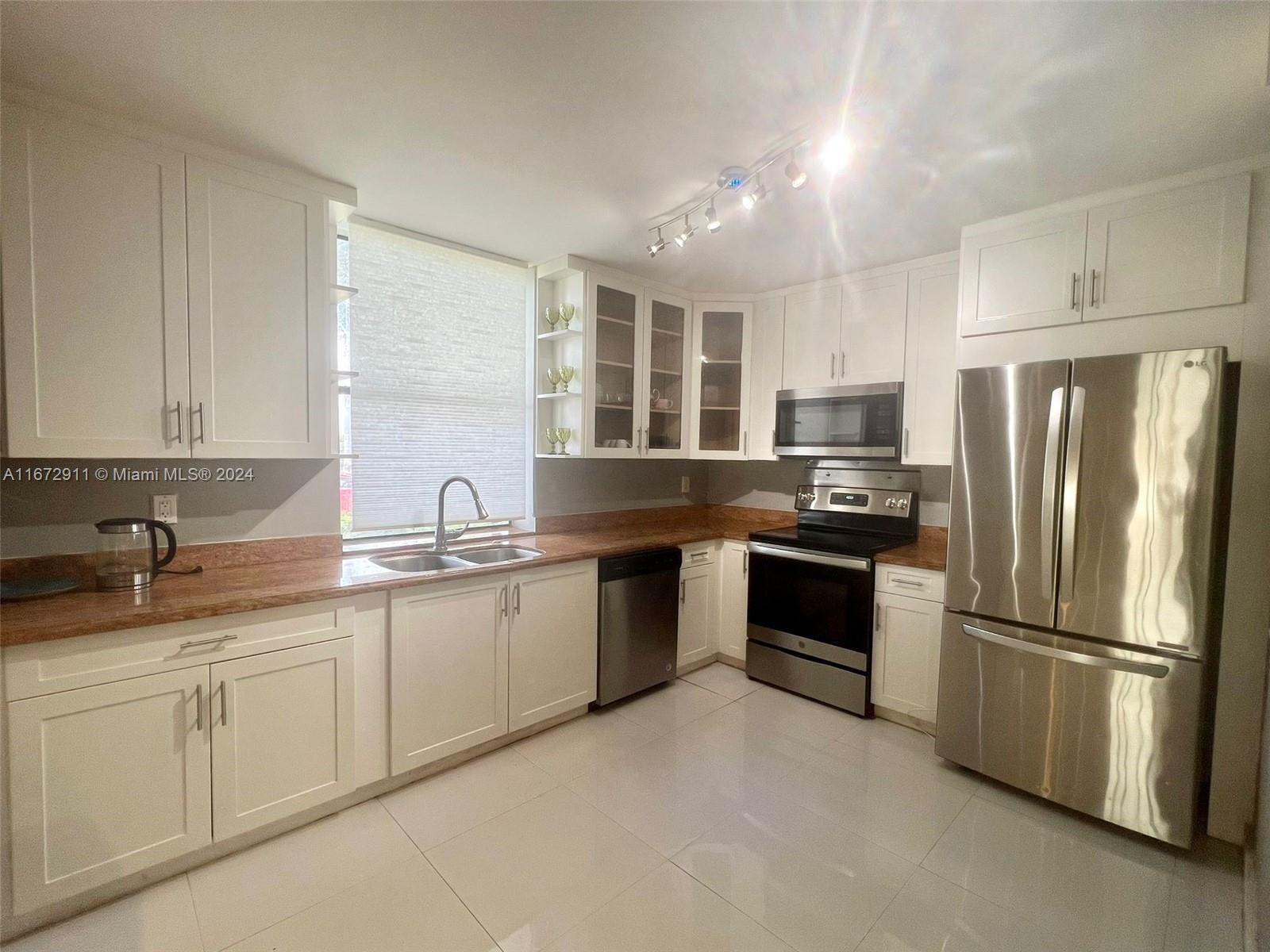 a kitchen with stainless steel appliances granite countertop a refrigerator sink and stove