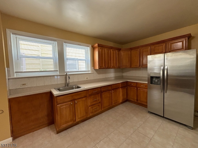 a kitchen with stainless steel appliances granite countertop a sink and a refrigerator