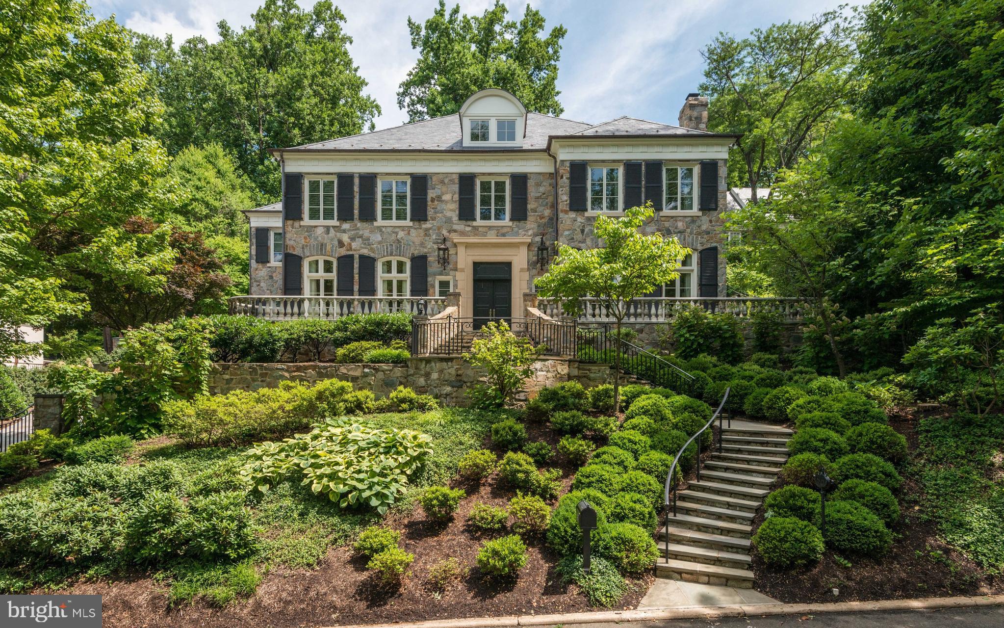 a front view of a house with a yard and potted plants