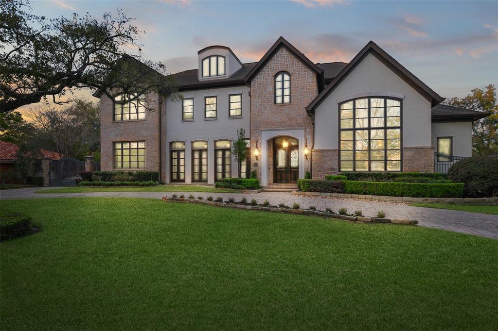 This stylish Tanglewood home boasts over 9,400 sq ft of living space on a 22,000+ sq ft lot, featuring a circular drive, gated driveway, porte-cochere, and three-car garage.