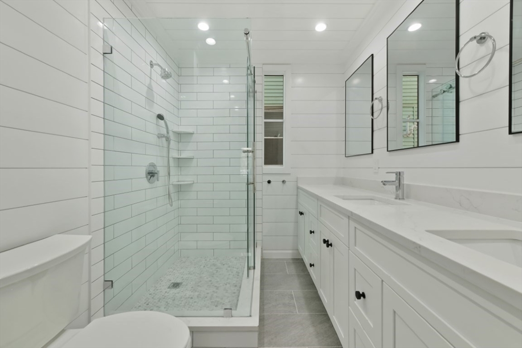 a bathroom with a double vanity sink toilet and shower