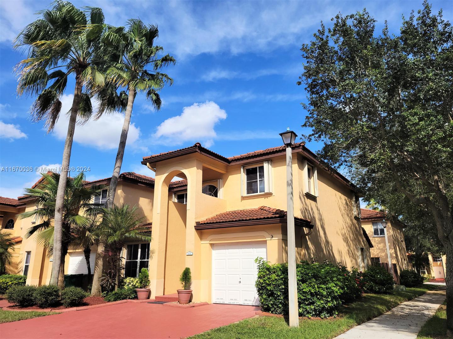 a front view of a house with a palm tree