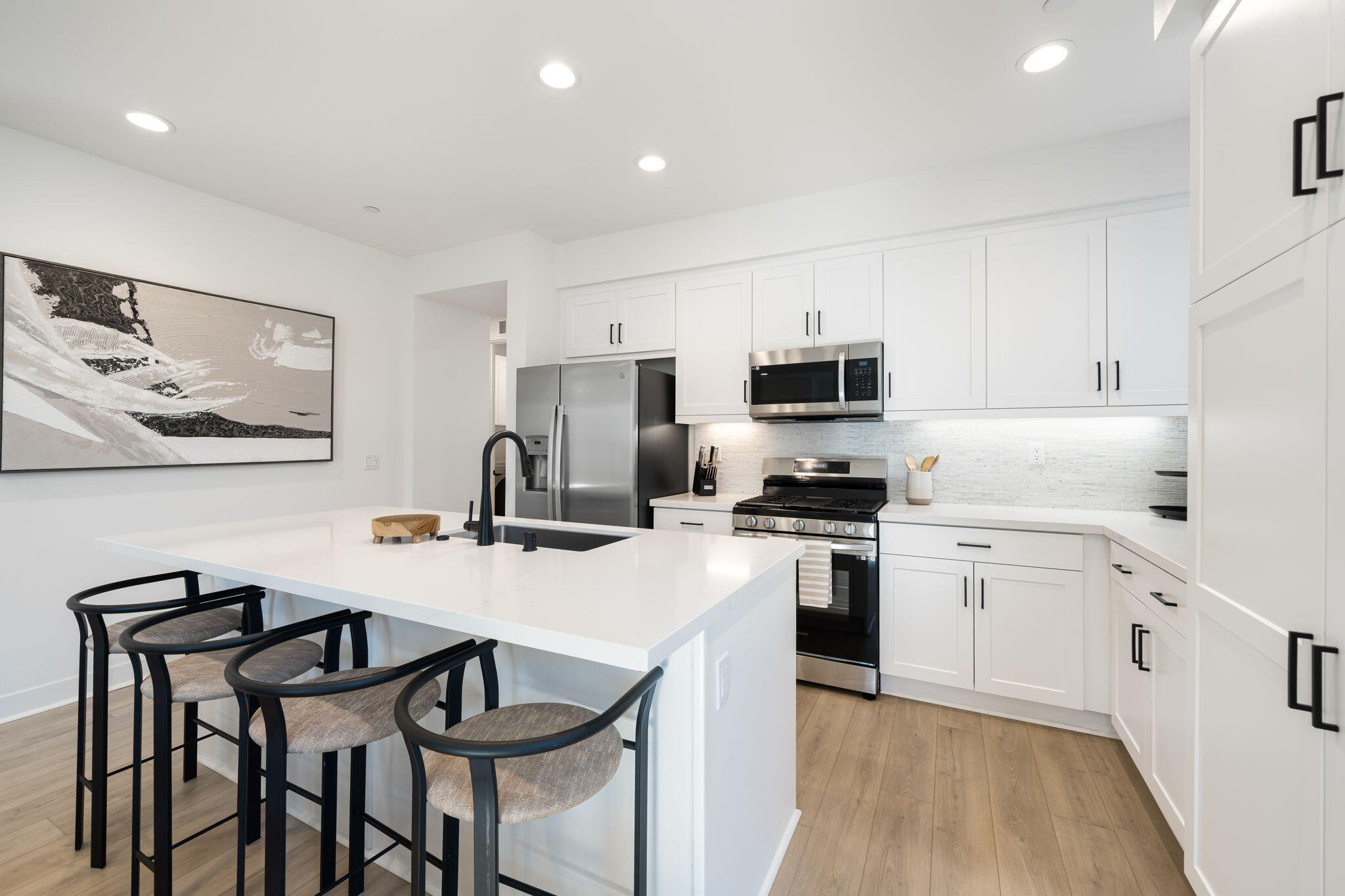 a kitchen with granite countertop white cabinets and stainless steel appliances