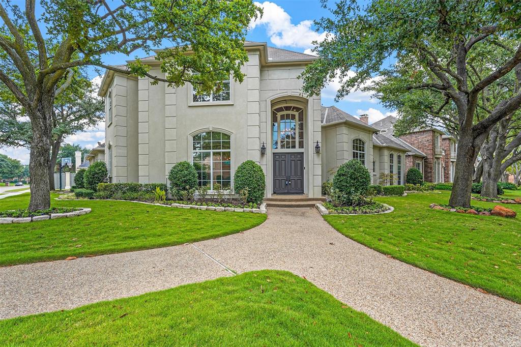 a front view of a house with a yard and trees