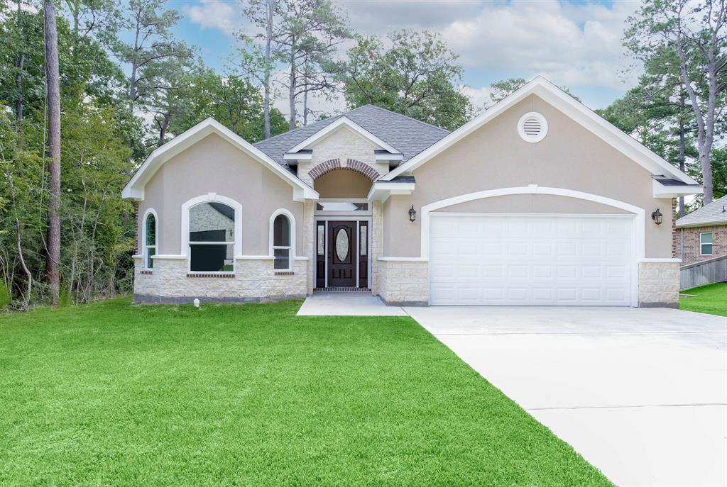 a front view of a house with a yard and garage