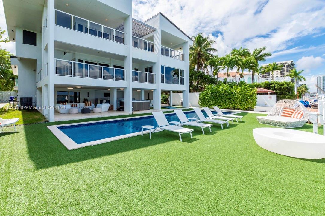 a view of an house with swimming pool and chairs