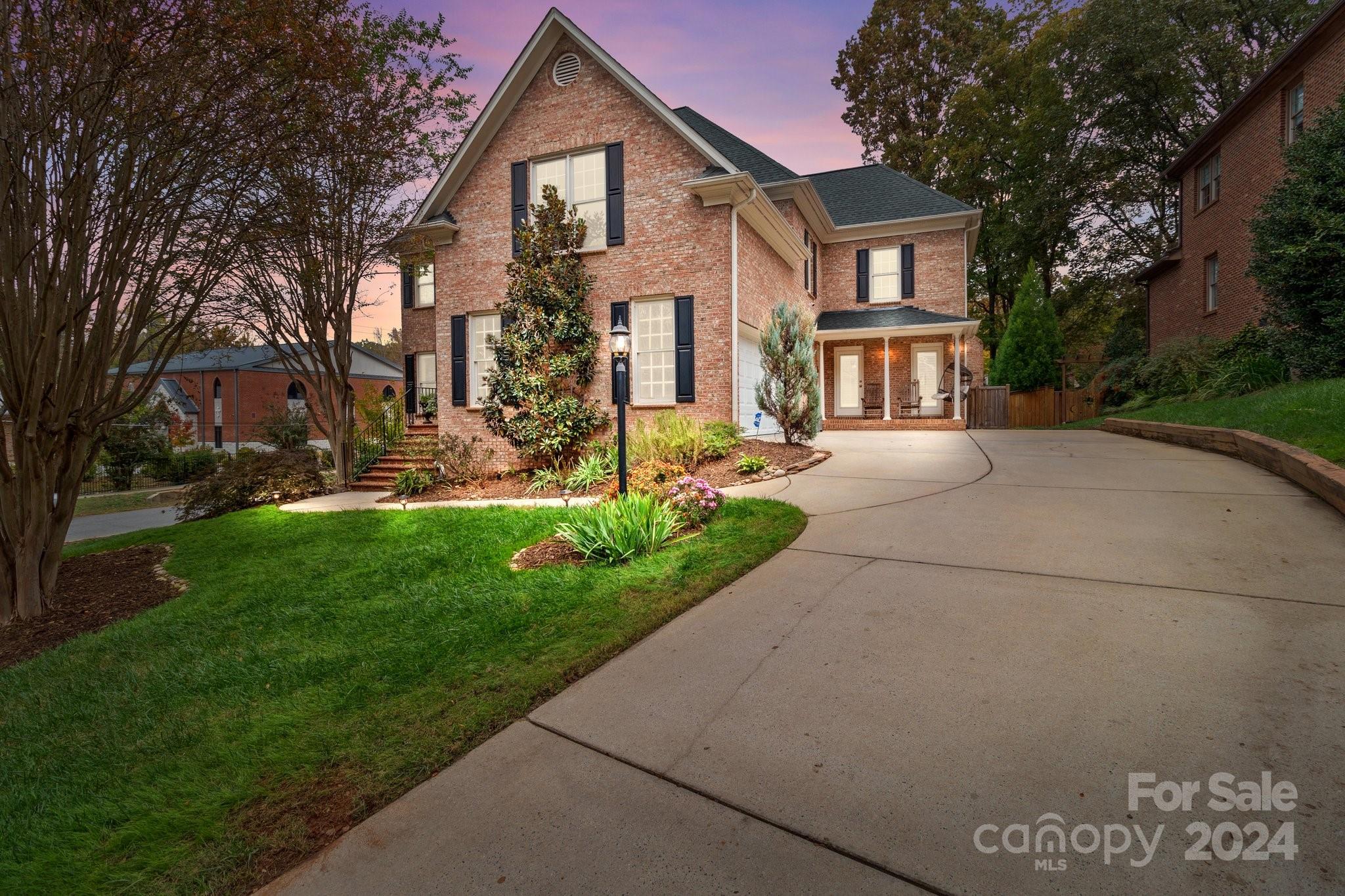 a front view of a house with a yard and trees