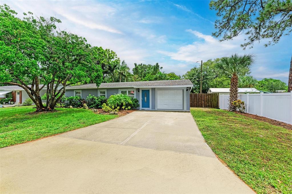 front view of a house with a yard and an trees