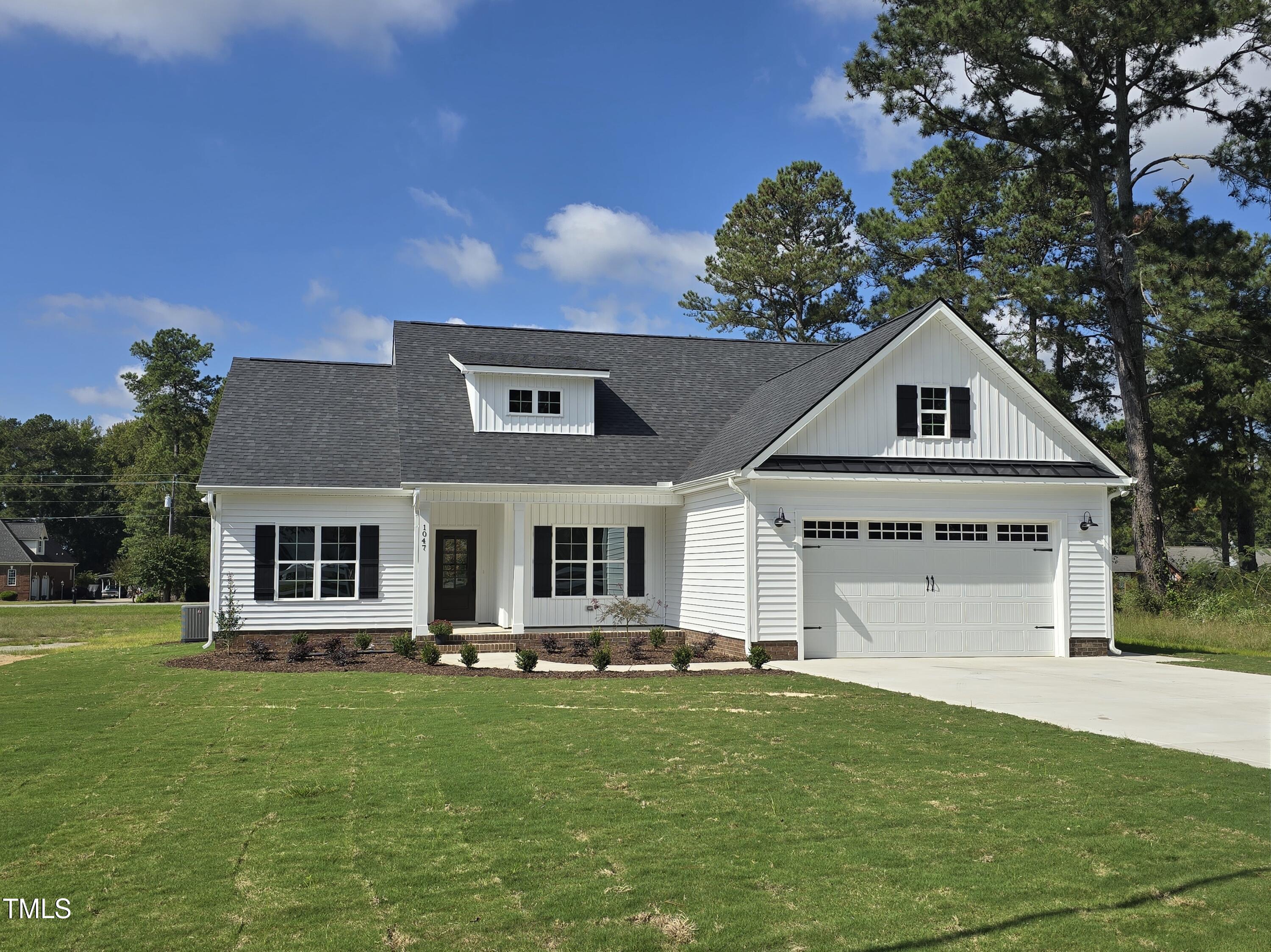 a front view of a house with a yard garage and outdoor seating