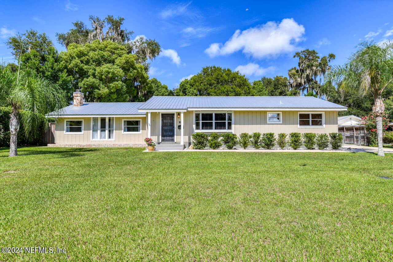 a view of house with yard and outdoor seating