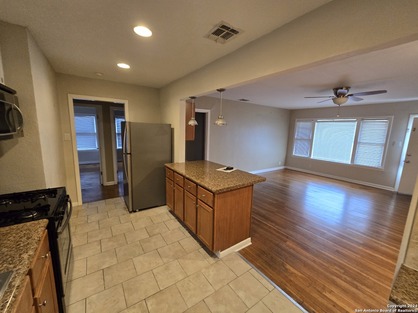 a living room with stainless steel appliances kitchen island granite countertop furniture and a kitchen view