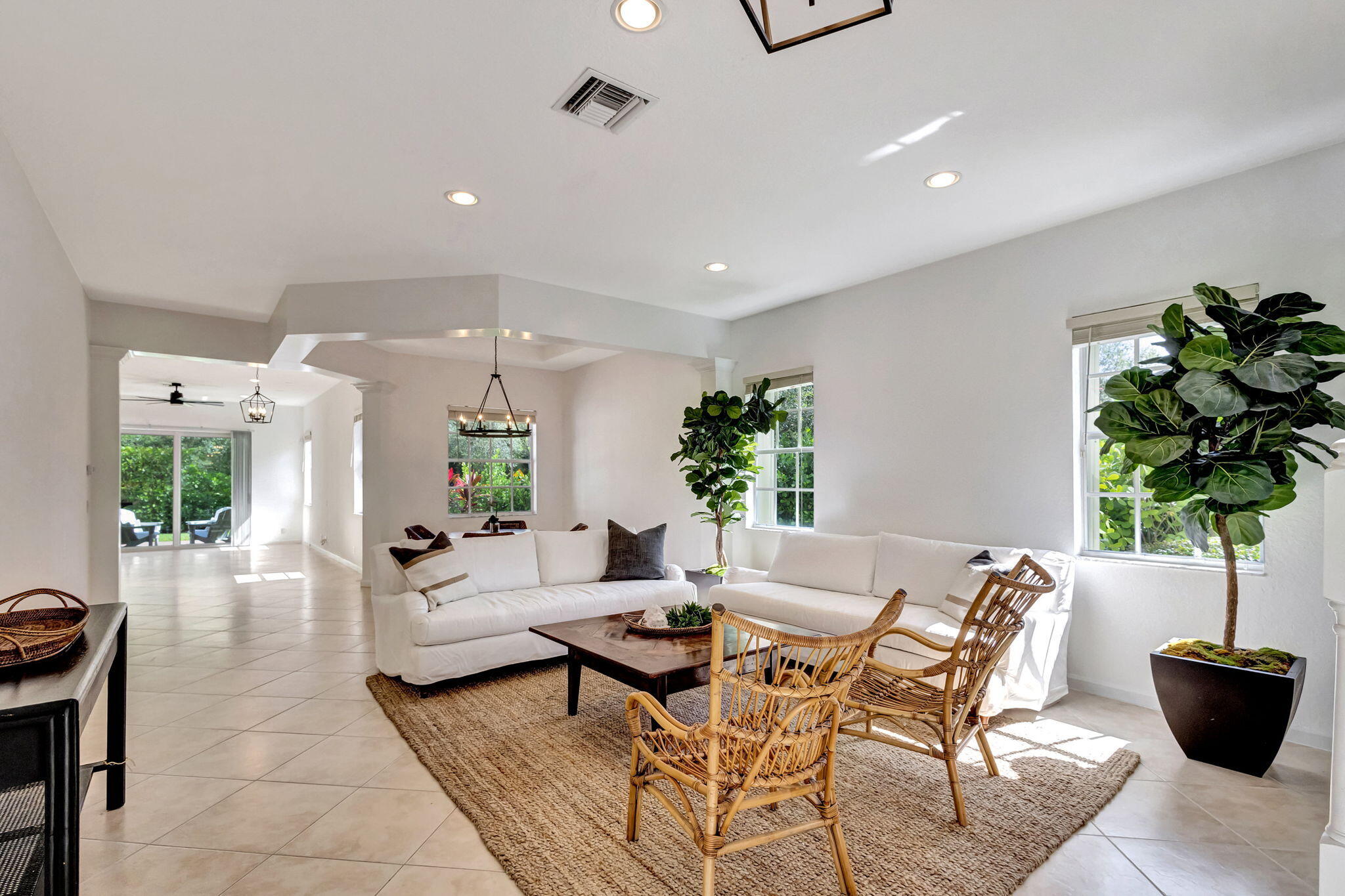 a living room with furniture a potted plant and a large window