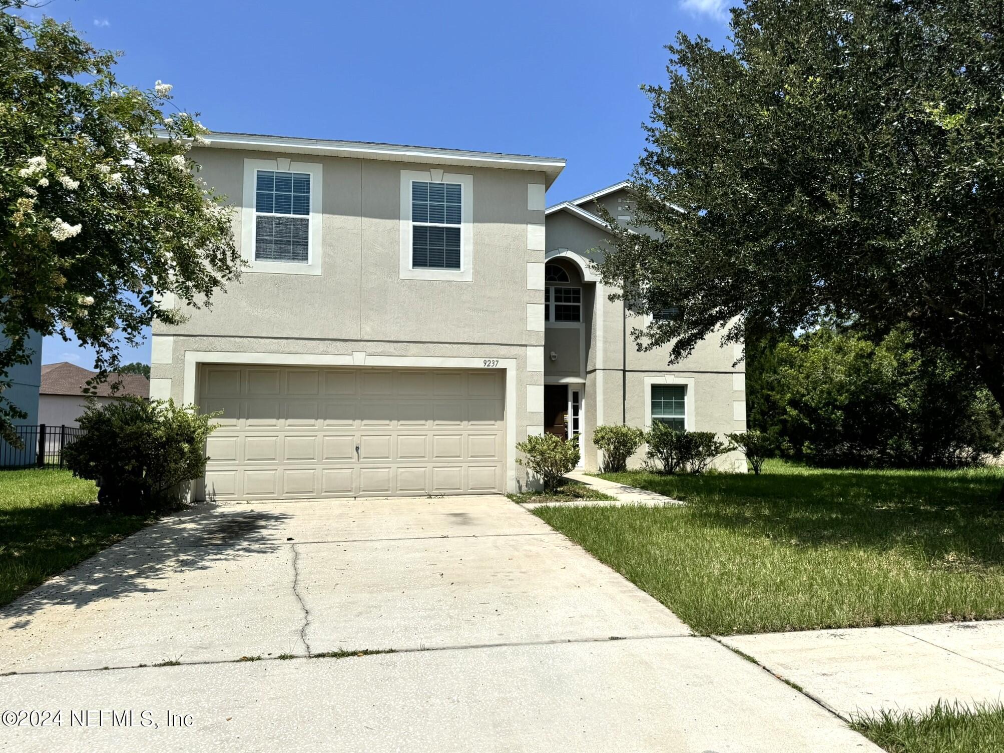 a front view of a house with a yard and garage