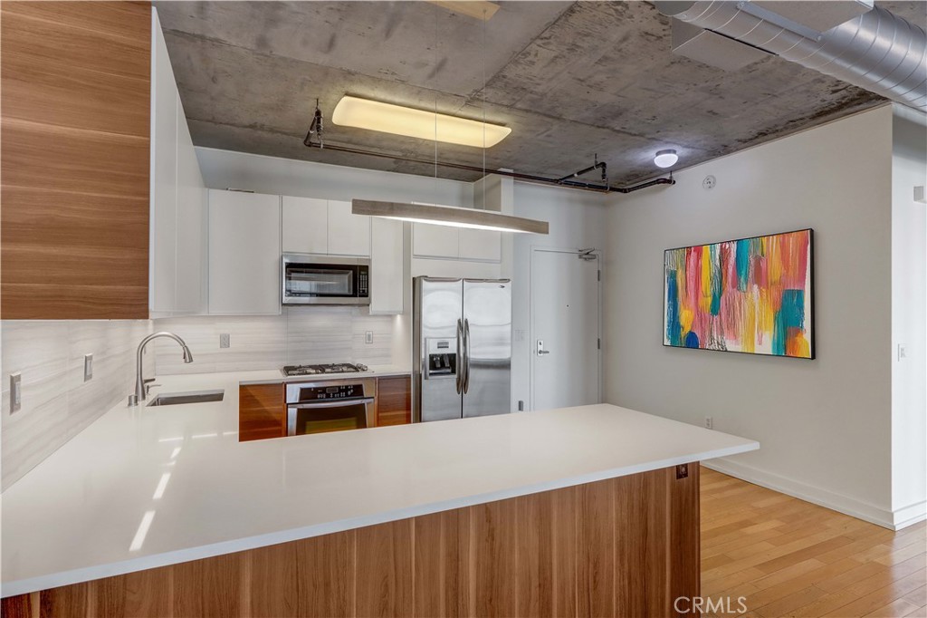 a kitchen with stainless steel appliances a stove sink microwave and cabinets