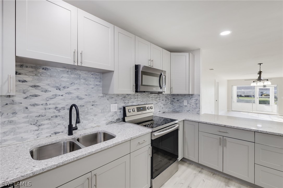 a kitchen with sink a microwave and cabinets