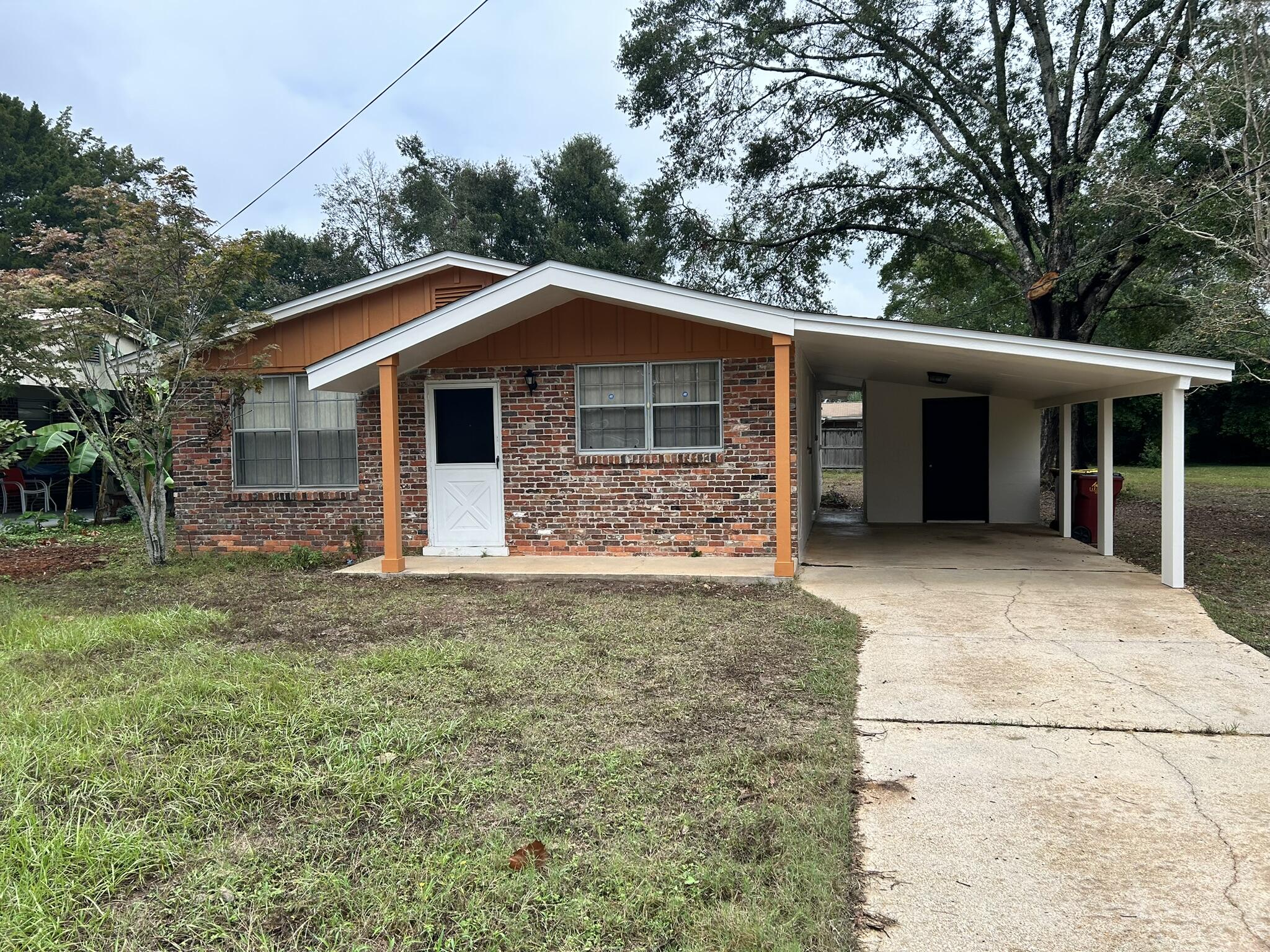 a view of a house with a yard and large tree