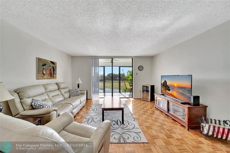 a living room with furniture large window and a flat screen tv