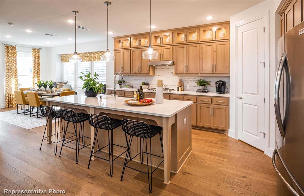 a kitchen with a table chairs refrigerator and cabinets