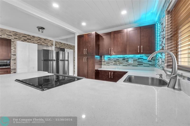 a kitchen with stainless steel appliances granite countertop a sink and a refrigerator